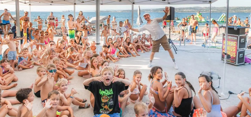 Čarodej in ventrilokvist Sam Sebastian in otroško občinstvo na plaži v Žusterni.